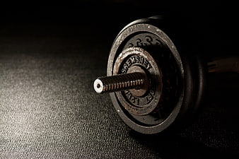 Close-up of vintage iron dumbbell on dark textured surface