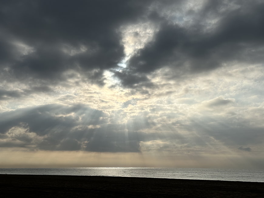 Dramatic Sun Rays Breaking Through Storm Clouds Over Ocean