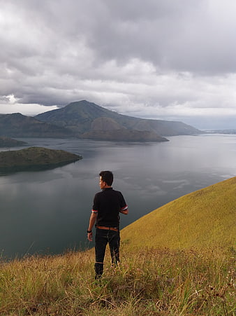 Man overlooking Lake Toba landscape in Samosir, Indonesia