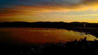 Aerial View of Golden Sunset Over Lake and Mountains