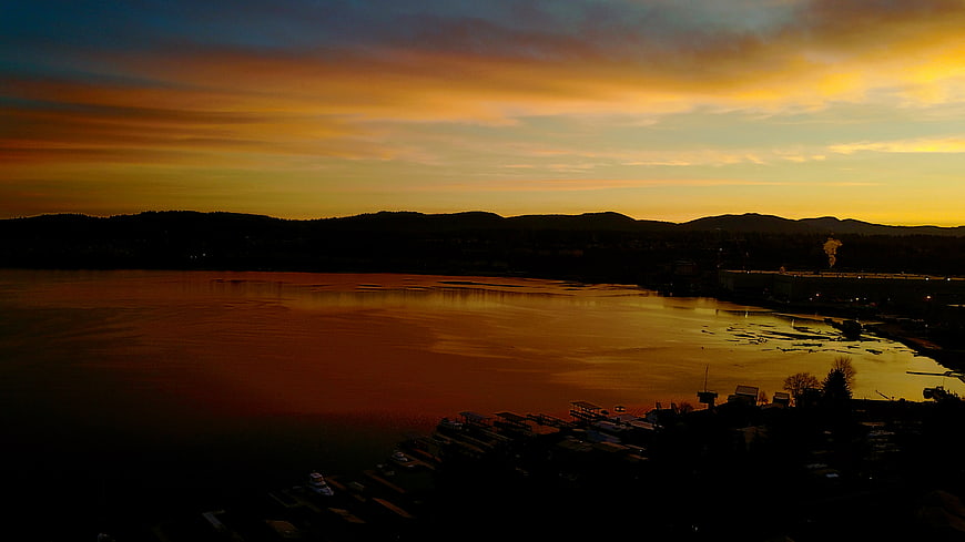 Aerial View of Golden Sunset Over Lake and Mountains