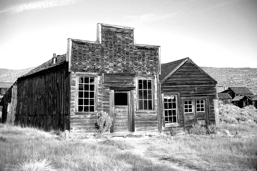 Black and white photo of abandoned wooden ghost town building
