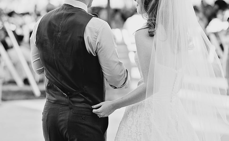 Bride and Groom Holding Hands at Outdoor Wedding Ceremony