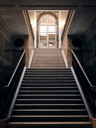 Symmetrical Grand Staircase Leading to Arched Window