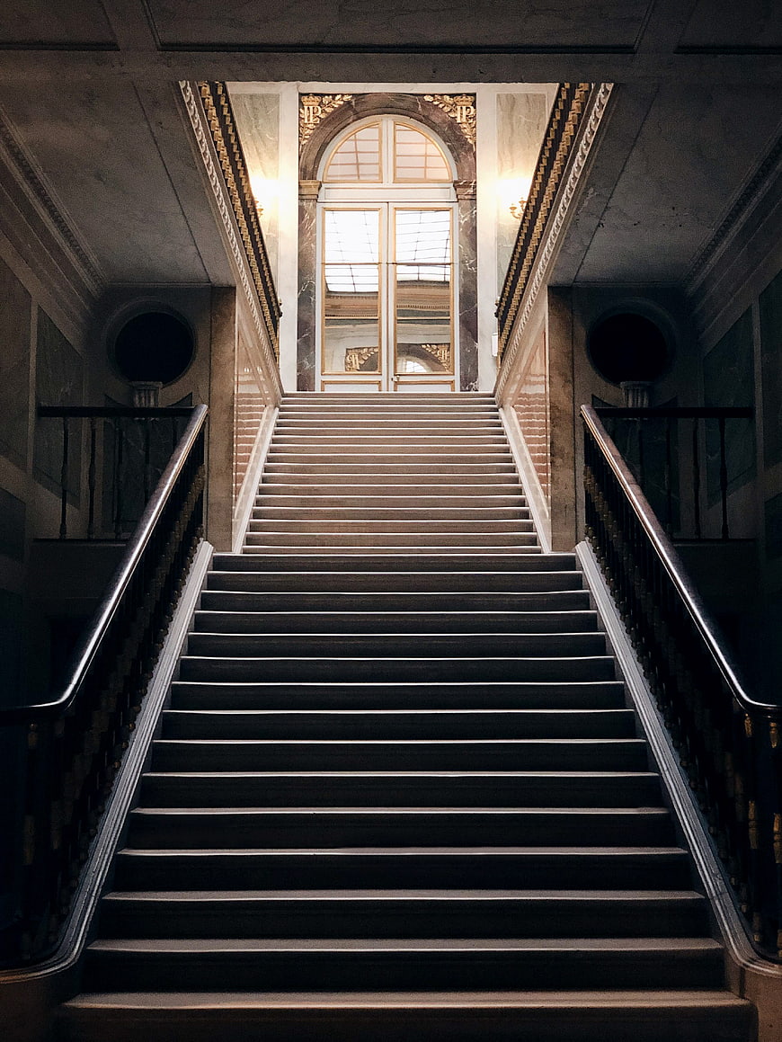 Symmetrical Grand Staircase Leading to Arched Window