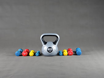 Silver Kettlebell and Colorful Dumbbells on Gray Background