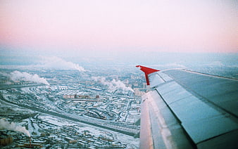 Aerial view of snowy industrial city from airplane window