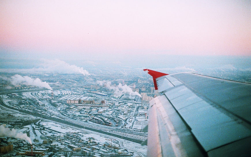 Aerial view of snowy industrial city from airplane window