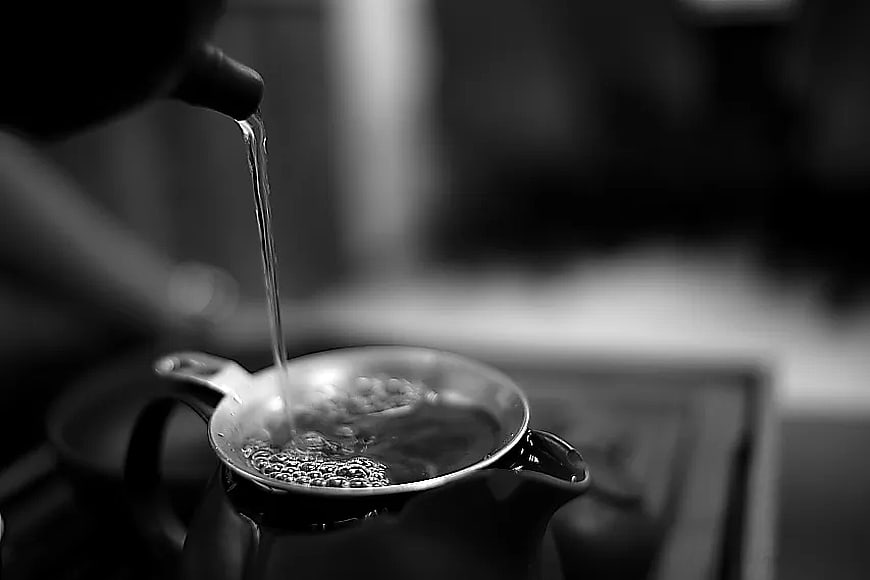 Black and white hot water pouring into teapot