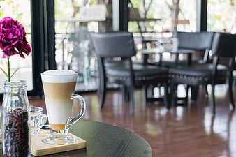 Layered Latte Coffee with Flower in Cafe Interior