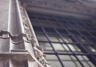 Close-up of ornate stone pillar with blurred window background