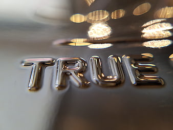 Close-up of chrome TRUE text on metallic surface