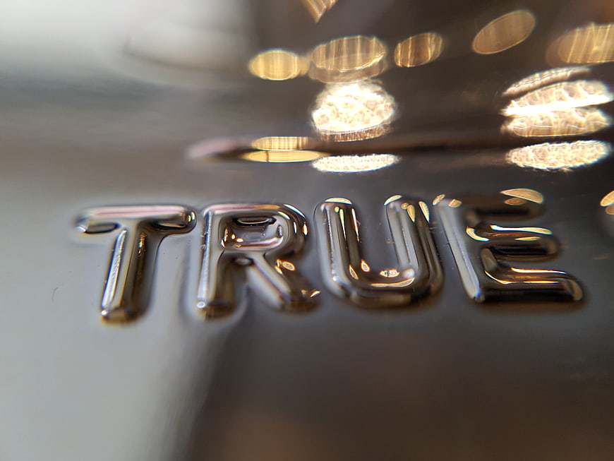 Close-up of chrome TRUE text on metallic surface