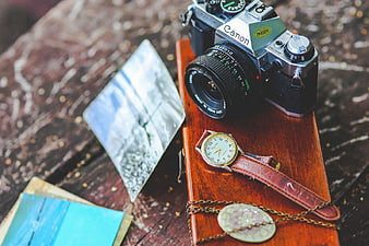 Vintage Canon Camera and Watch on Wooden Surface