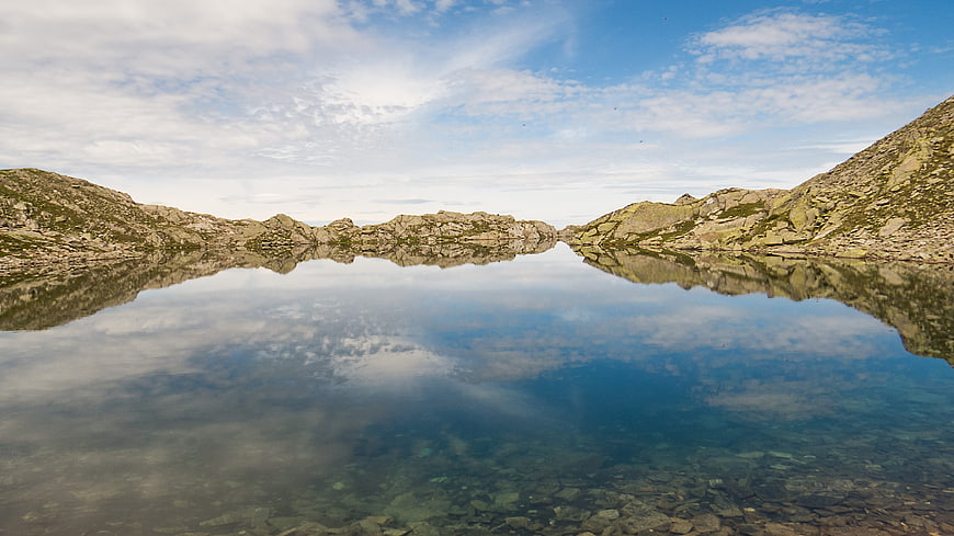 Serene mountain lake with perfect reflection in High Tauern, Austria