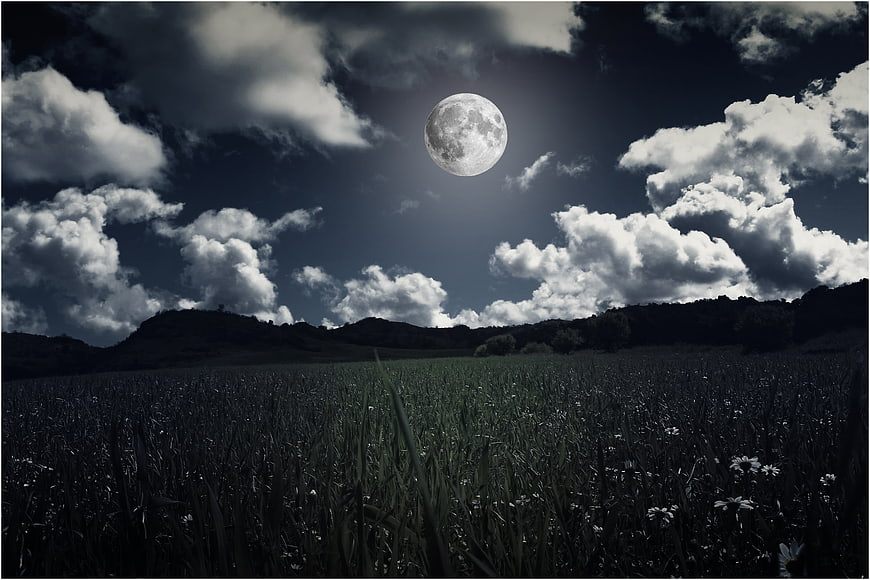 Full Moon Over Dark Meadow Landscape With Dramatic Clouds