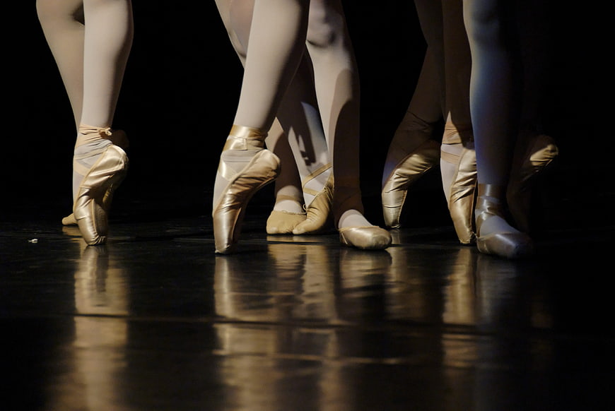 Ballet Dancers' Feet in Pointe Shoes on Stage