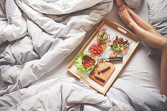 Healthy breakfast in bed on wooden tray with legs