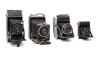 Collection of vintage German folding cameras on white background