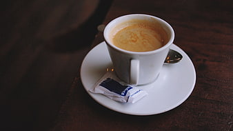 White cup of espresso coffee on wooden table