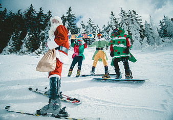 Santa Claus and elves skiing and snowboarding in snowy forest