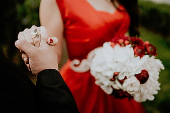 Couple Holding Hands with Red Dress and White Bouquet