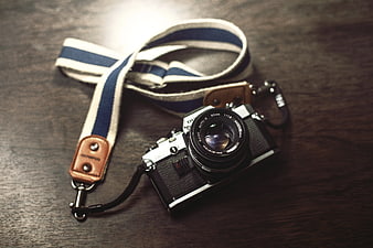Vintage Film Camera with Striped Lanyard on Wood