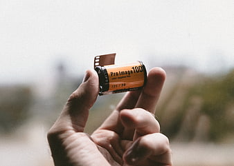 Hand holding Pro Image 100 film roll outdoors