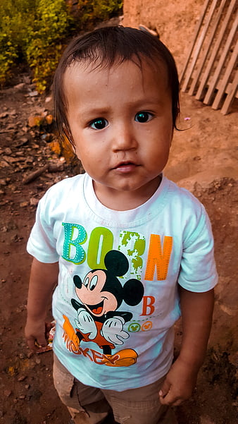 Portrait of a toddler boy wearing a Mickey Mouse shirt outdoors