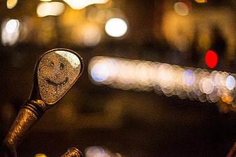 Smiley face reflection in scooter mirror with bokeh lights