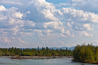 Wide river landscape with autumn aspen trees and dramatic clouds