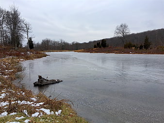 Frozen Lake Landscape in Winter with Snowy Banks