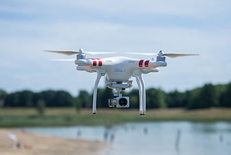White DJI Phantom Drone Hovering Over Lake
