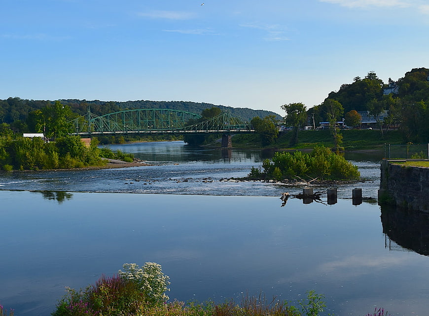 Green Truss Bridge Over River With Reflections