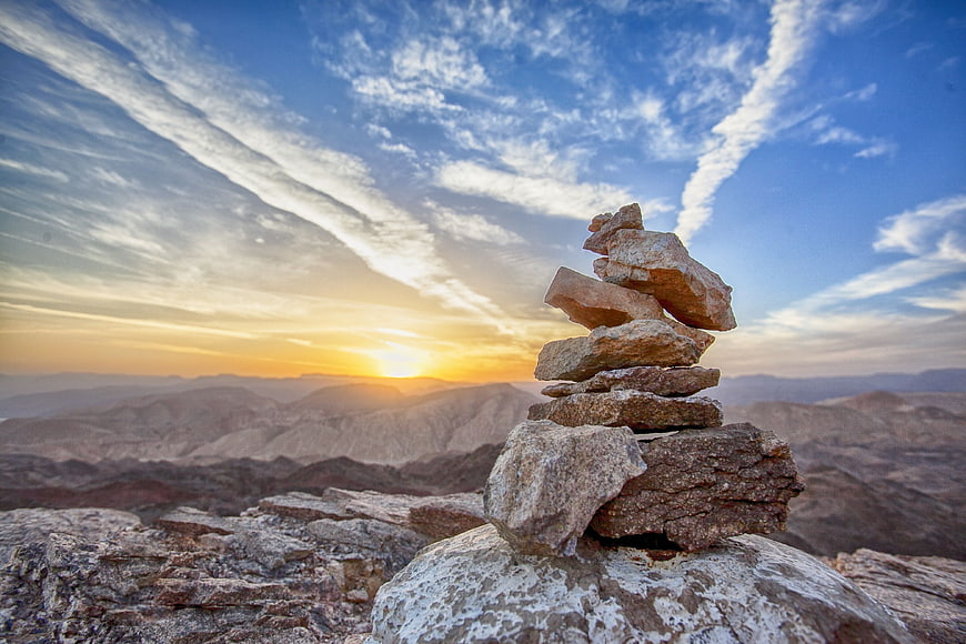 Stacked Rock Cairn on Mountain Peak at Sunset