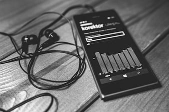 Black and white smartphone with equalizer app and earphones