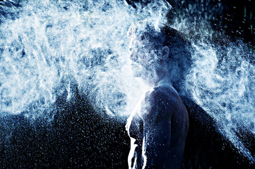 Man dissolving into blue energy particles