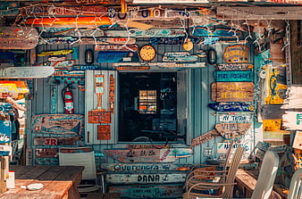 Colorful Surfboard Signs on Blue Beach Shack Wall