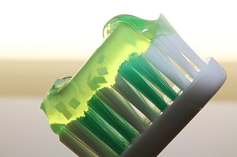 Macro shot of green toothbrush bristles with gel toothpaste