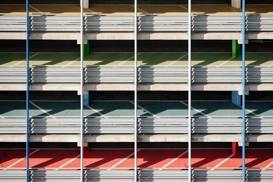 Colorful parking garage facade with metal slats and shadows