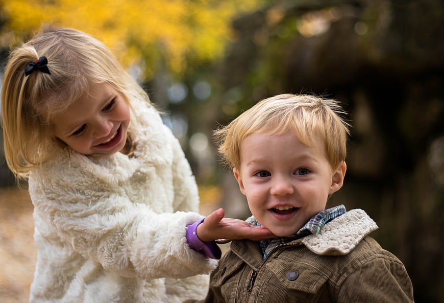 Happy Siblings Playing Outdoors in Autumn Park