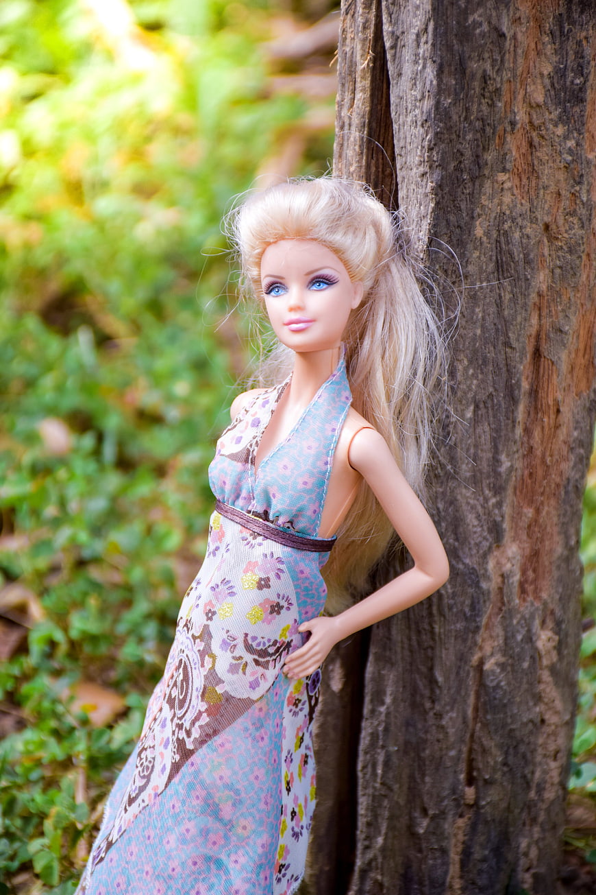 Blonde Fashion Doll in Floral Dress Leaning Against Tree