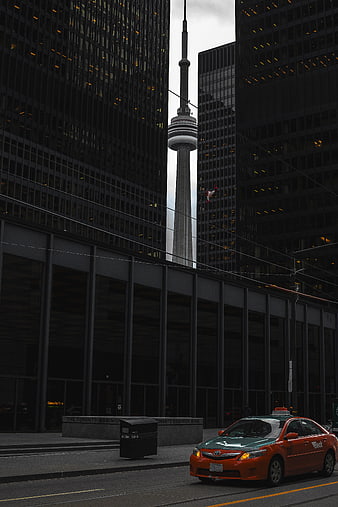 Toronto CN Tower framed by skyscrapers with taxi