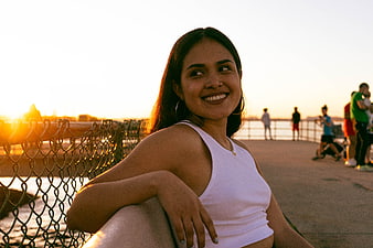 Smiling Woman Leaning on Pier at Sunset