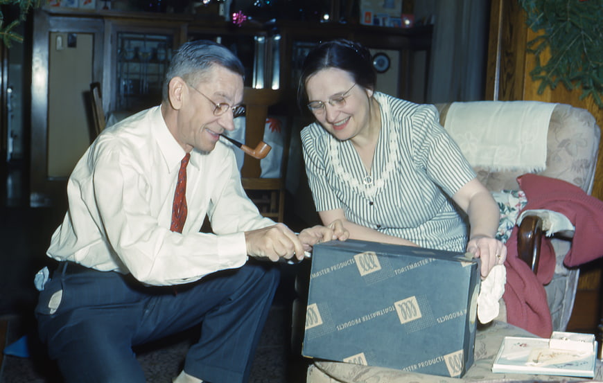 Senior couple opening a gift box together at home