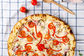 Overhead View of Fresh Pizza with Tomatoes on Checkered Tablecloth