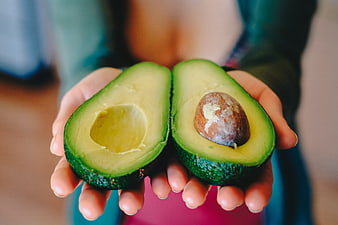 Hands Holding Halved Fresh Avocado