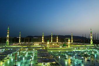 Masjid Nabawi Mosque at Dusk with Minarets and Crowd