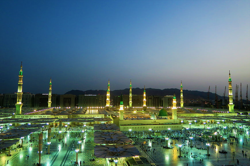 Masjid Nabawi Mosque at Dusk with Minarets and Crowd