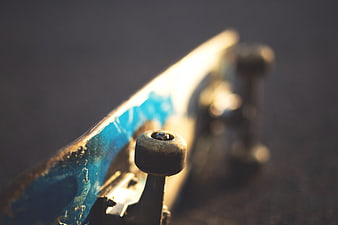Close-up of worn blue skateboard deck and wheels